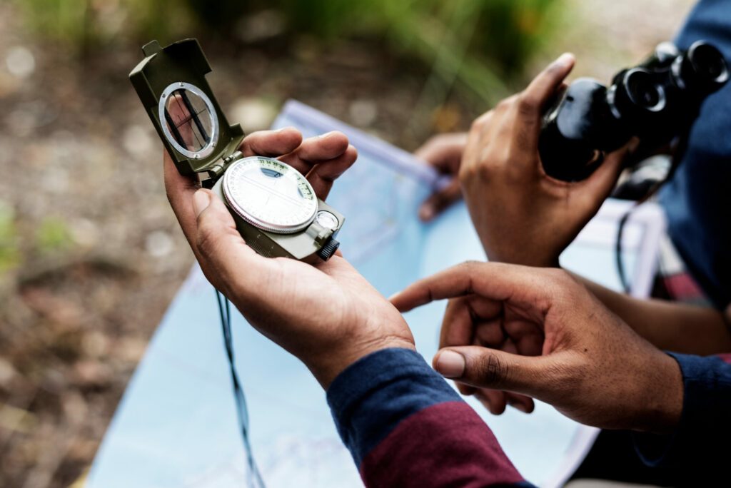 Trekking,Couple,Using,Map,And,Compass,In,A,Forest