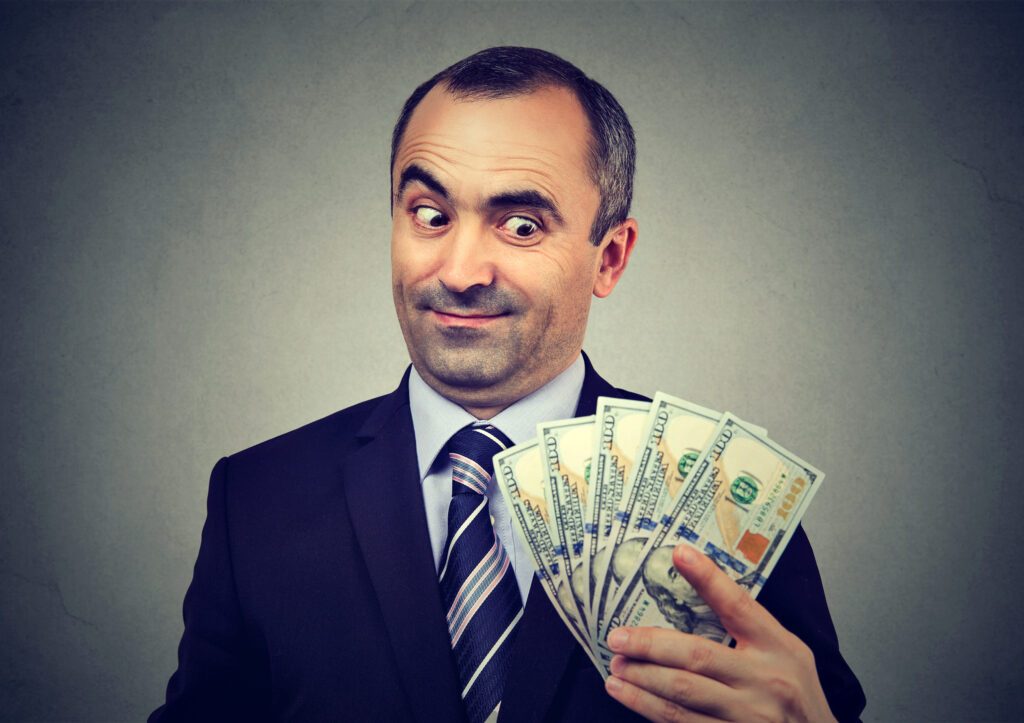 Funny sly business man holding looking at money